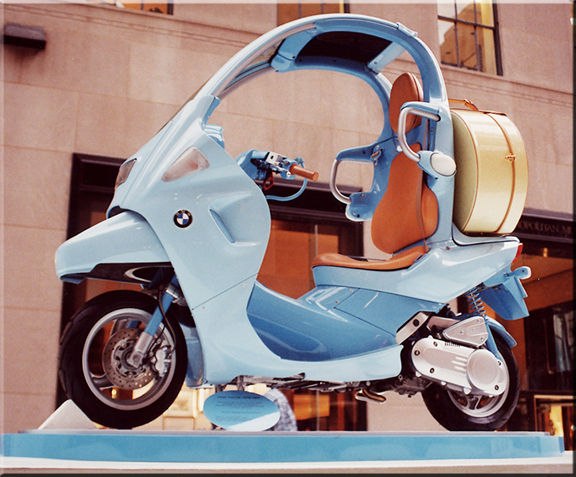 BMW C1 azzurra esposta con sella in cuoio e baule coordinato.