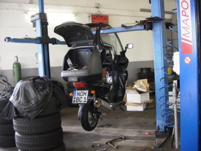 BMW C1 nera sollevata in un’officina per la manutenzione.