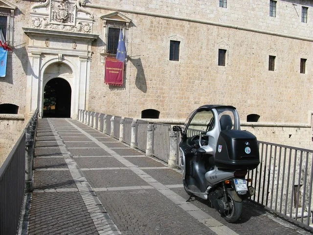 BMW C1 au château de L’Aquila, vue de trois quarts.
