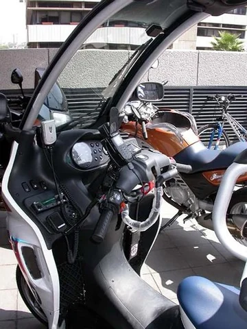 Habitacle d'une BMW C1 de secours, doté d'une radio et de commandes supplémentaires.