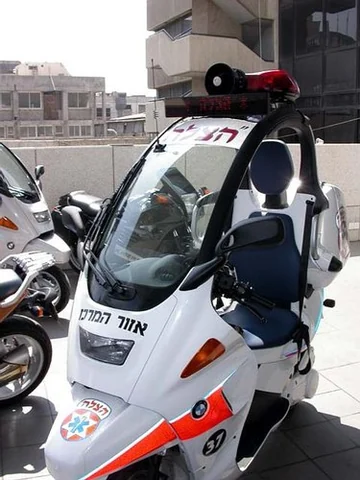 BMW C1 blanche équipée pour les secours, avec sirène, gyrophare et coffre médical.